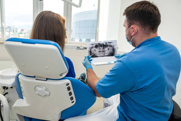 na odontologia profissional, um dentista que conhece seu negócio tira fotos para um paciente com dentes doentes. O conceito de imagens de dentes em pacientes - Foto, Imagem