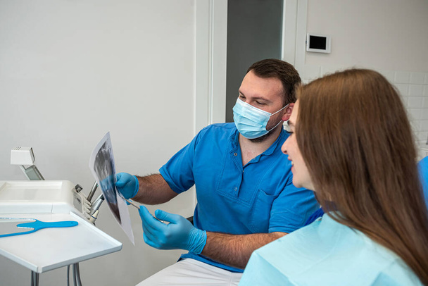 na odontologia profissional, um dentista que conhece seu negócio tira fotos para um paciente com dentes doentes. O conceito de imagens de dentes em pacientes - Foto, Imagem