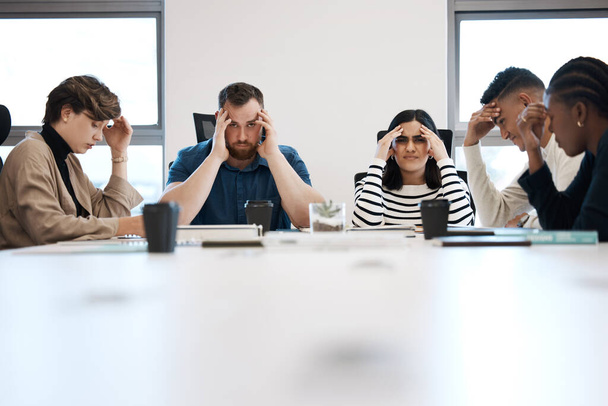 a group of business people clutching their heads in pain. - Fotoğraf, Görsel