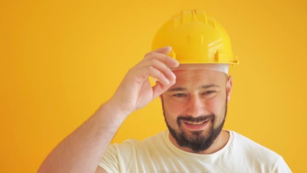 stavební dělník v pevném klobouku na žlutém pozadí. - Záběry, video