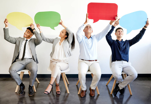 a group of businesspeople holding speech bubbles in an office at work. - 写真・画像