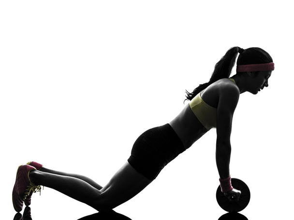 woman exercising fitness workout abdominal toning wheel silhouet - 写真・画像