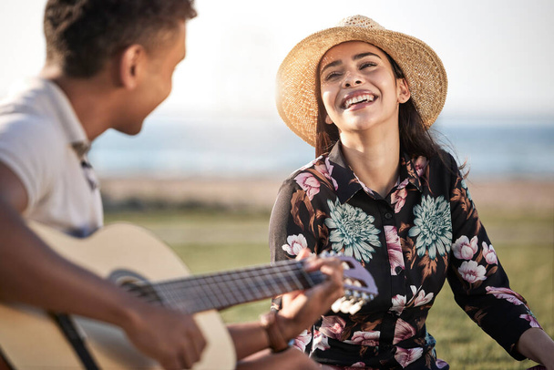 um jovem tocando guitarra em um piquenique com sua namorada. - Foto, Imagem