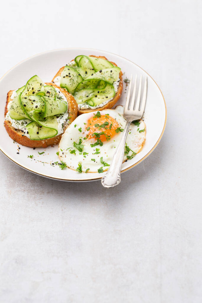 Keto Toasts with ricotta, egg, cucumber and black sesame. - 写真・画像
