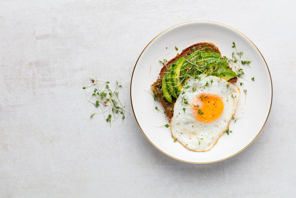 Keto breakfast fried egg, avocado and bread in a white plate. Keto diet concept. - Fotoğraf, Görsel