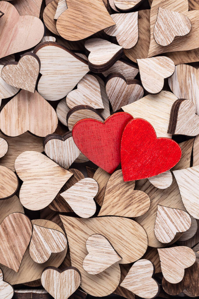 Wooden hearts, one red heart on the heart background. - Фото, изображение