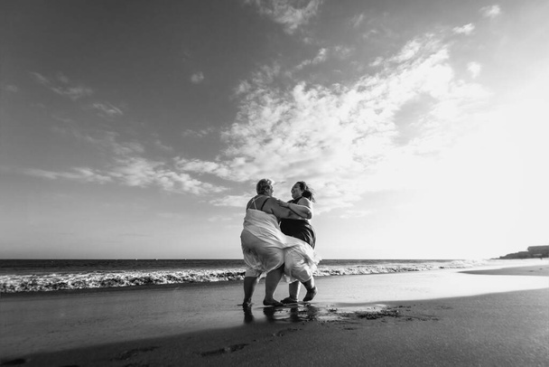 Yaz tatili boyunca kumsalda eğlenen mutlu ve iri kadınlar, kendine güvenen insanlar yaşam tarzı konsepti, siyah ve beyaz kurgu. - Fotoğraf, Görsel