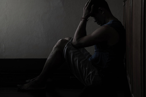Desperate hopeless man with hands holding head sitting in dark corner  - Foto, immagini