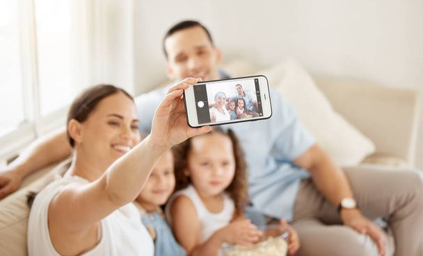 une femme prenant un selfie à la maison avec sa famille. - Photo, image
