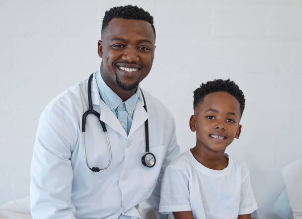 a young male doctor having a checkup with a little boy at a hospital. - Photo, image