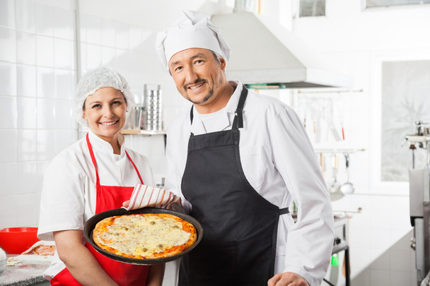 Confident Chefs With Pizza Pan At Commercial Kitchen - Фото, зображення