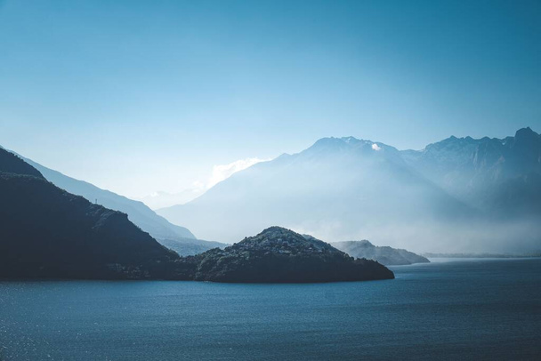 A breathtaking view of mountains bordering the sea against blue sky - Valokuva, kuva
