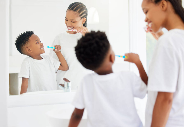 little boy and his mother brushing their teeth together in a bathroom at home. - Photo, image