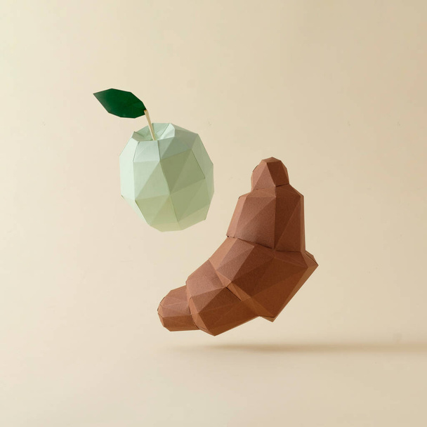 Chocolate 3d polygon croissant and green apple levitation on a beige background. Minimal creative pastel concept of delicious and healthy food and diet. - Φωτογραφία, εικόνα
