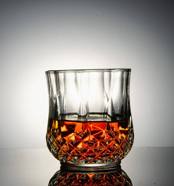 A glass of whisky on a gray background - Zdjęcie, obraz