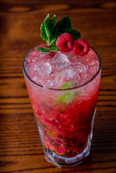 A vertical closeup of Raspberry mojito on wooden table - Foto, Imagem