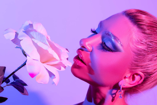 Moda donna modello con un luminoso make-up in luci al neon luminose colorate in posa in studio. - Foto, immagini