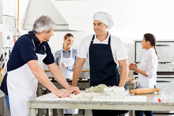 Chefs Talking While Preparing Pasta At Commercial Kitchen - Foto, Bild