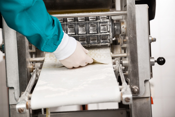Chefs Hand Removing Ravioli Pasta From Machine - Foto, immagini