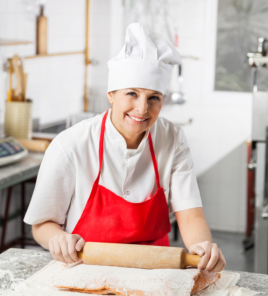 Smiling Female Chef Rolling Pasta Sheet At Counter - Foto, imagen