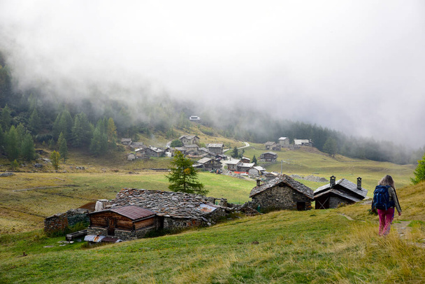 Passeggiate su un sentiero in Valle d'Aosta vicino al paese di Chaneil con nuvole basse  - Foto, immagini
