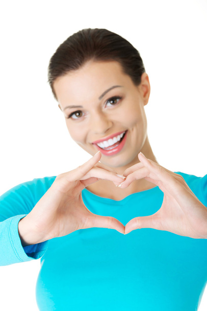 Portrait of happy woman making heart sign - Photo, image