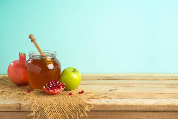 Jewish holiday Rosh Hashana background with honey, apple and pomegranate on wooden table - Foto, Imagem