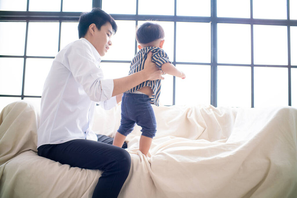Ofis işleri babası rahat bir odada kanepede çalıştıktan sonra küçük çocukla oynuyor. - Fotoğraf, Görsel