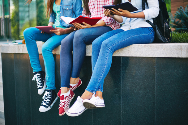 Chicas en jeans leyendo afuera
 - Foto, Imagen