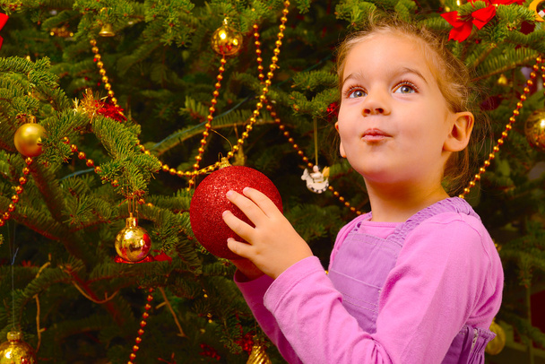 entzückende Kleinkind Mädchen halten dekorative Weihnachten Spielzeugkugel - Foto, Bild