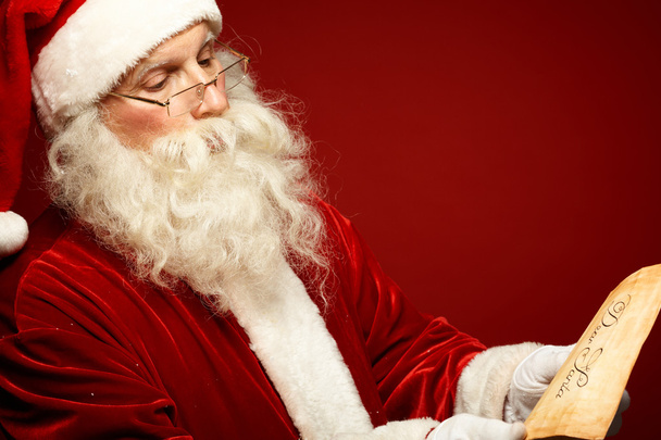 Santa Claus leyendo la carta de Navidad
 - Foto, Imagen