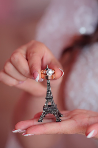 Anillos de boda en una Torre Eiffel en miniatura
 - Foto, imagen