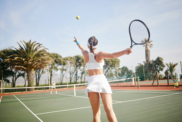 Неузнаваемый теннисист, стоящий на корте и подающий мяч во время тренировки. - Фото, изображение
