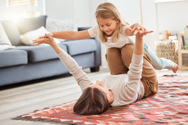 a young mother and daughter playing in the lounge at home. - 写真・画像