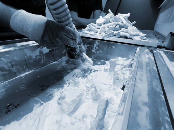 Чоловік, який працює з робочим пилососом, щоб очистити білий порошок поліаміду від моделі, надрукованої на 3D-принтері всередині 3D-принтера. Очищення об'єктів, надрукованих на промисловому порошковому 3D принтері
 - Фото, зображення