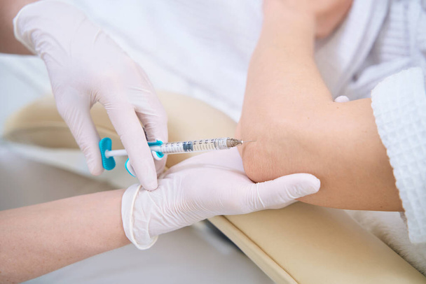 Injections with a syringe in the elbow for skin tightening - Photo, Image