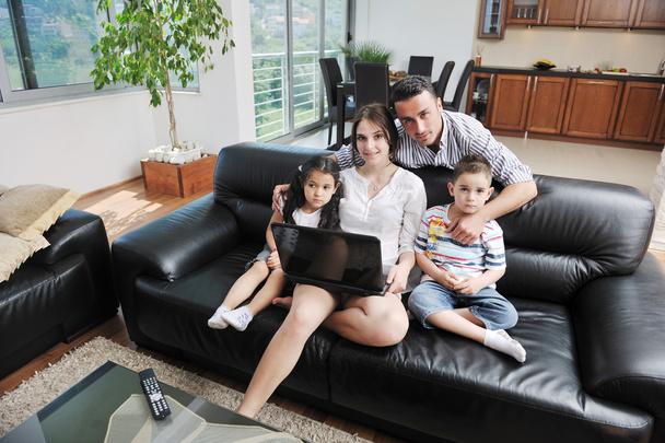 Happy young family have fun and working on laptop at home - 写真・画像