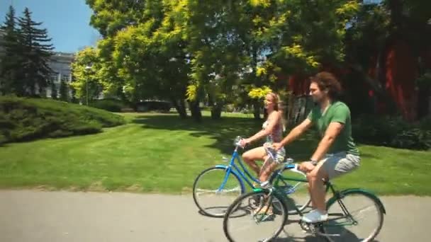 Couple enjoying cycling through park - Záběry, video