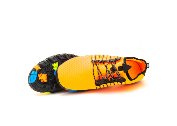 Side view of single bright orange water shoes with upper mesh material elastic like socks snug feet skin softly isolated on white background. Breathable, quick-dry fashionable shoes for men women - 写真・画像