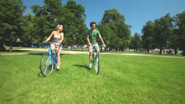Ζευγάρι που απολαμβάνουν ποδηλασία μέσα από το πάρκο - Πλάνα, βίντεο