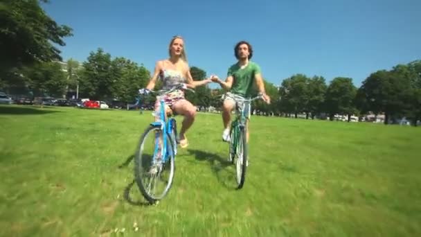 Pár, kteří požívají, jízda na kole přes park - Záběry, video