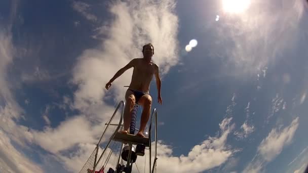 Człowiek, skacząc do morza z łodzi - Materiał filmowy, wideo