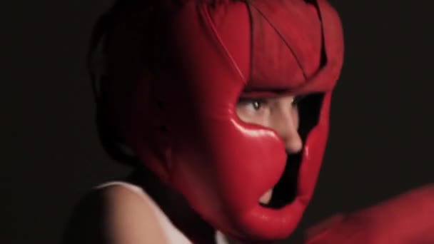 Guy boxeador golpea sus puños en el aire mientras entrena para una pelea. Joven boxeo con cara de sombra de primer plano - Imágenes, Vídeo