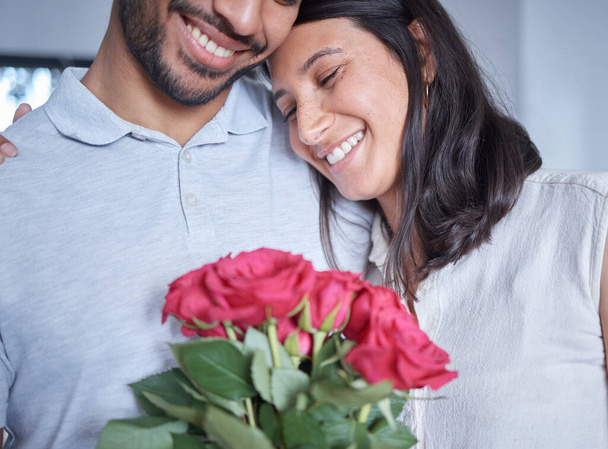 an unrecognizable man surprising his girlfriend with flowers at home. - Foto, imagen