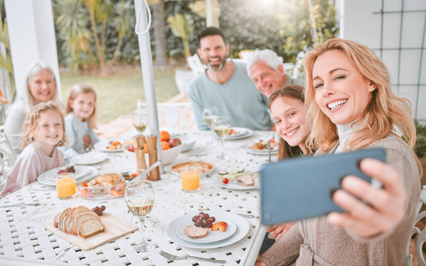 μια οικογένεια που βγάζει selfie ενώ γευματίζει στο σπίτι. - Φωτογραφία, εικόνα