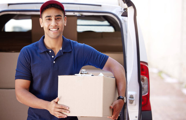 Retrato de um jovem entregador carregando caixas de uma van. - Foto, Imagem