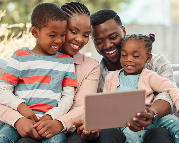 une famille utilisant une tablette numérique ensemble à la maison. - Photo, image