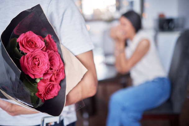 un uomo irriconoscibile sorprende la sua ragazza con fiori a casa. - Foto, immagini