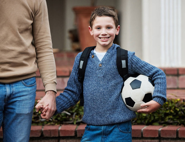 Маленький мальчик, готовый идти в школу с футбольным мячом. - Фото, изображение
