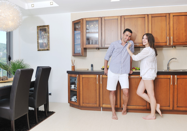 Happy young couple have fun in modern kitchen - Foto, afbeelding